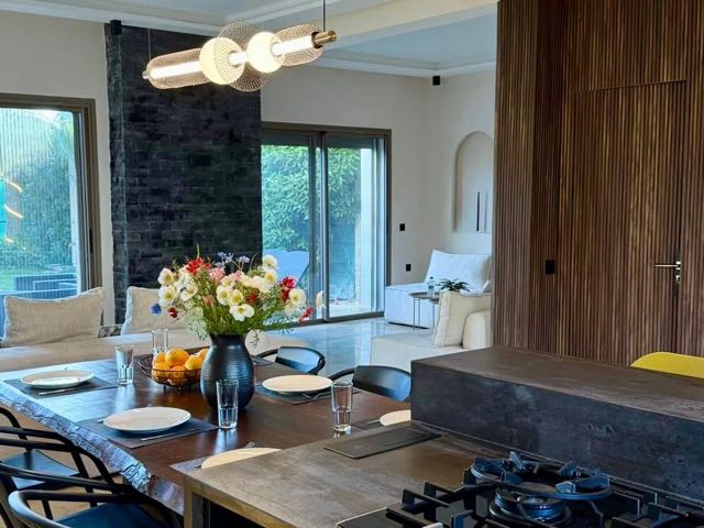 Cuisine, table et vue sur le jardin à Villa Silya, villa avec piscine à Sidi Rahal